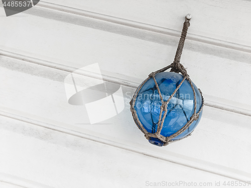 Image of Blue glass ball decorating a white wooden wall