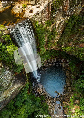 Image of Waterfall tumbling over the sheer cliffs to idyllic waterhole