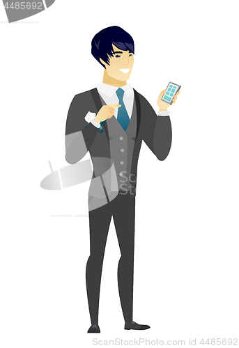 Image of Asian groom holding a mobile phone.