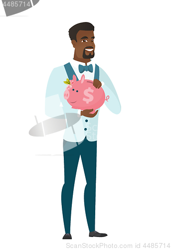 Image of African-american groom holding a piggy bank.