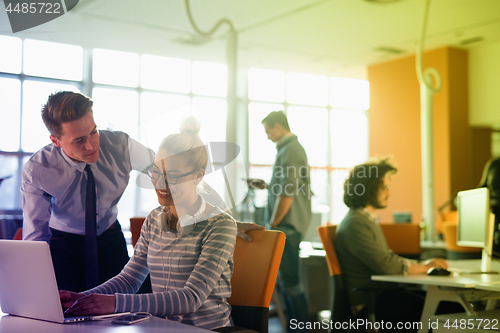 Image of Two Business People Working With laptop in office