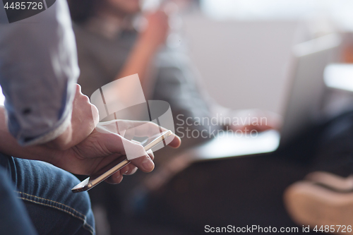 Image of Young man holding smartphone