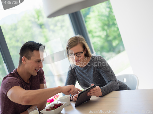 Image of couple enjoying morning coffee and strawberries