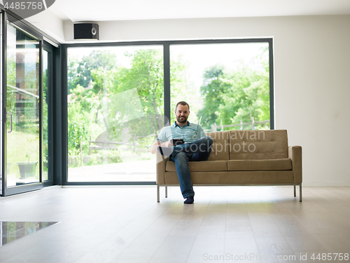 Image of man on sofa using tablet computer