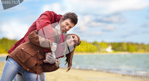 Image of happy couple having fun over autumn beach