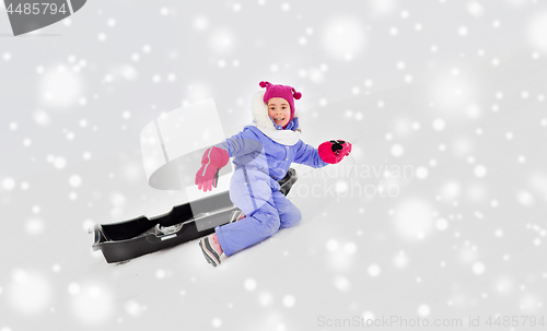 Image of little girl with sled on snow hill in winter