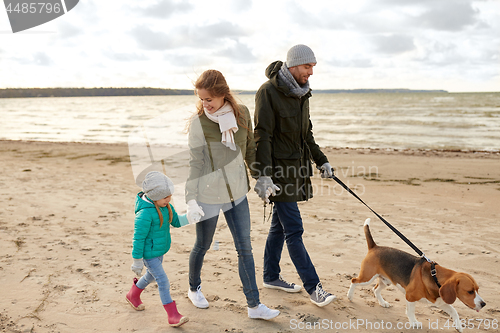 Image of happy family walking with beagle dog in autumn