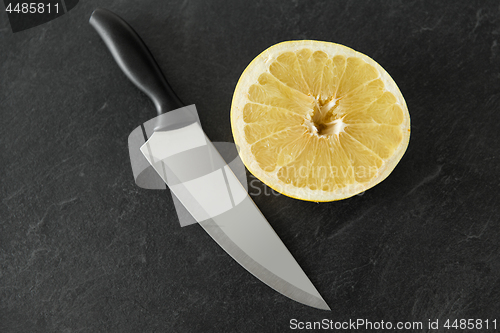Image of close up of chopped lemon and knife on table
