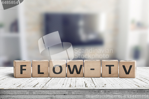 Image of Flow-tv sign on a wooden table in a living room