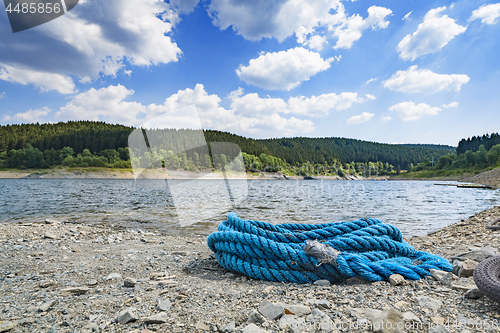 Image of Blue rope on a pebble beach in the summer