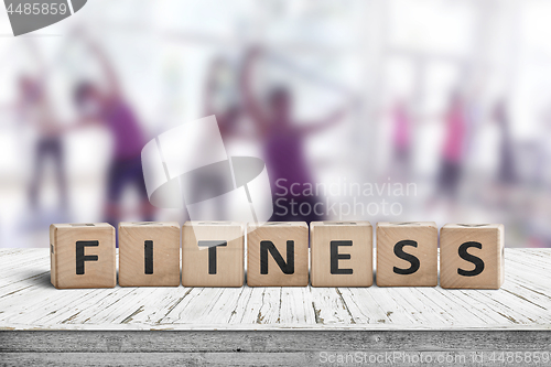 Image of Fitness sign on a table in a gym with women