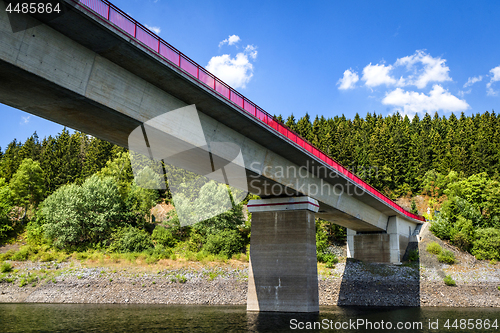 Image of Bridge with red fence over a lake in the summer