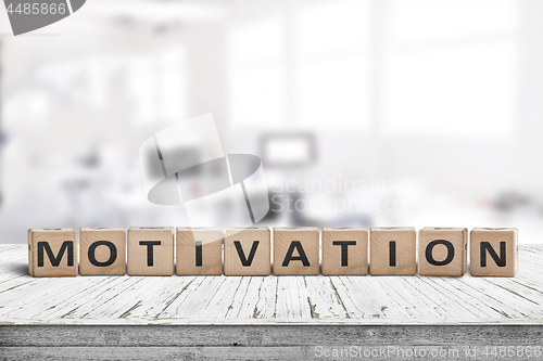 Image of Motivation sign on a desk in a bright office