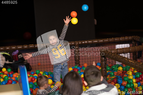 Image of young parents with kids in a children\'s playroom