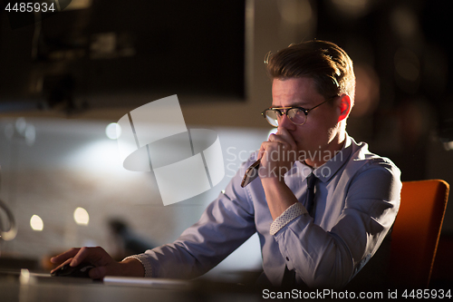 Image of man working on computer in dark office