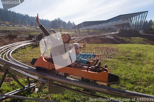 Image of mother and son enjoys driving on alpine coaster