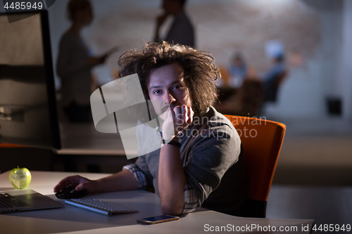 Image of man working on computer in dark office