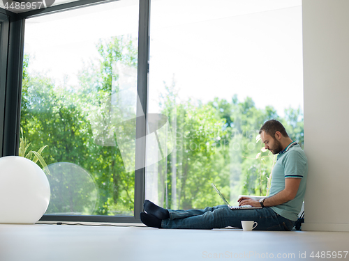 Image of man drinking coffee on the floor enjoying relaxing lifestyle