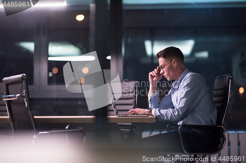 Image of man working on laptop in dark office