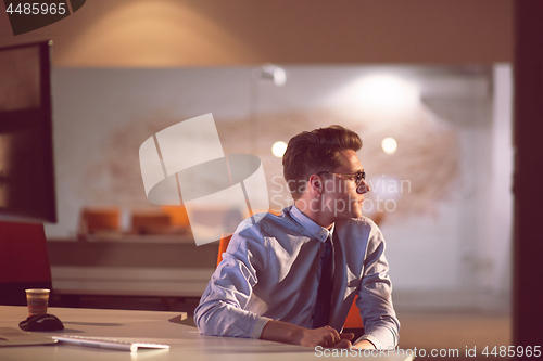 Image of man working on computer in dark office