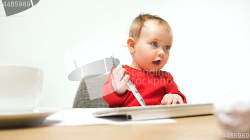 Image of Happy child baby girl toddler sitting with keyboard of computer isolated on a white background