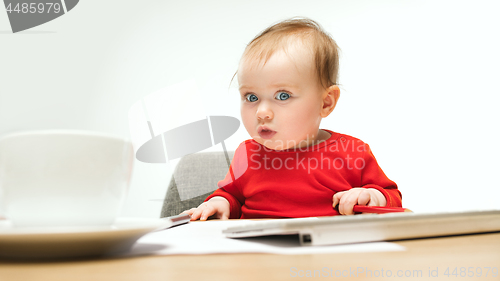 Image of Happy child baby girl toddler sitting with keyboard of computer isolated on a white background