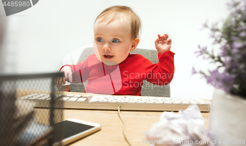 Image of Happy child baby girl toddler sitting with keyboard of computer isolated on a white background