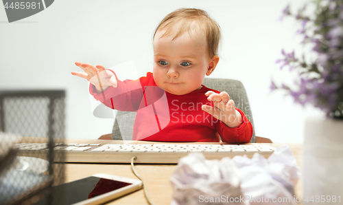Image of Happy child baby girl toddler sitting with keyboard of computer isolated on a white background