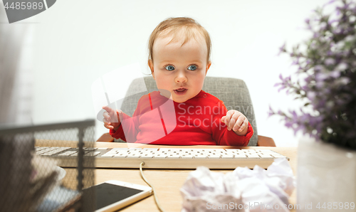 Image of Happy child baby girl toddler sitting with keyboard of computer isolated on a white background