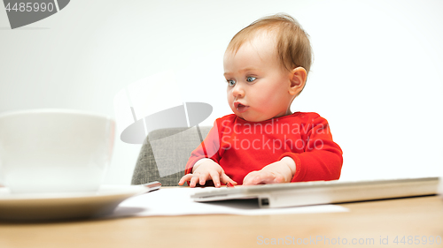 Image of Happy child baby girl toddler sitting with keyboard of computer isolated on a white background