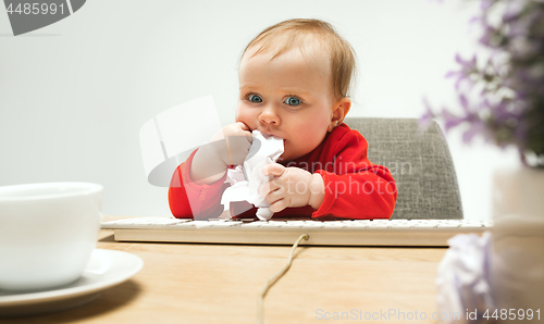 Image of Happy child baby girl toddler sitting with keyboard of computer isolated on a white background