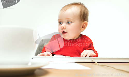 Image of Happy child baby girl toddler sitting with keyboard of computer isolated on a white background