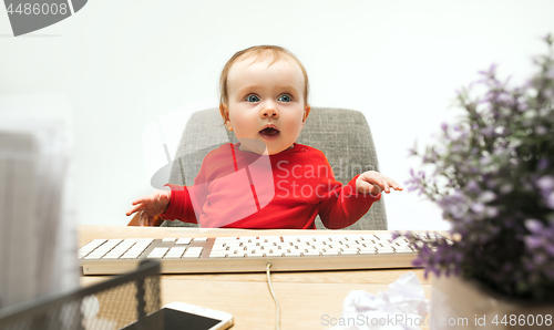 Image of Happy child baby girl toddler sitting with keyboard of computer isolated on a white background