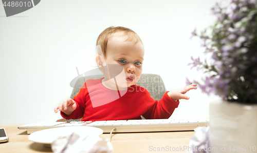 Image of Happy child baby girl toddler sitting with keyboard of computer isolated on a white background