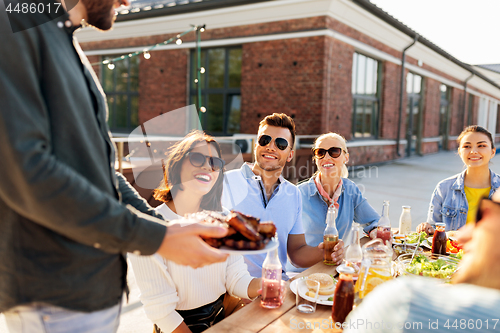 Image of friends at barbecue party on rooftop in summer