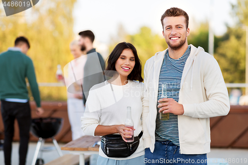 Image of happy couple with drinks at rooftop party