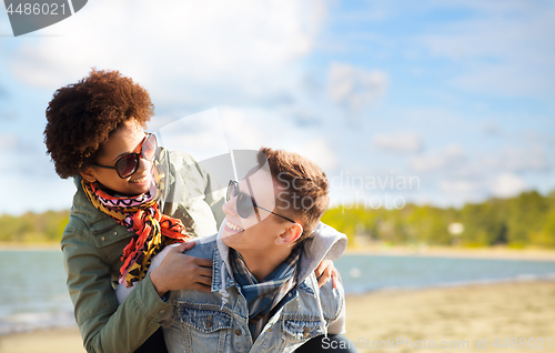 Image of happy teenage couple in shades having fun on beach