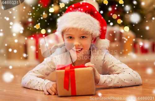 Image of smiling girl in santa hat with christmas gift