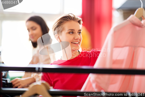 Image of woman choosing clothes at vintage clothing store