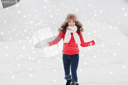 Image of happy woman in winter fur hat outdoors