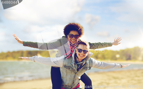 Image of happy teenage couple in shades having fun on beach