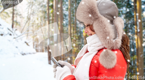 Image of happy woman with smartphone in winter