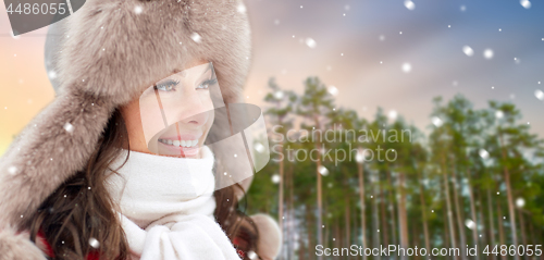 Image of happy woman in fur hat over winter forest