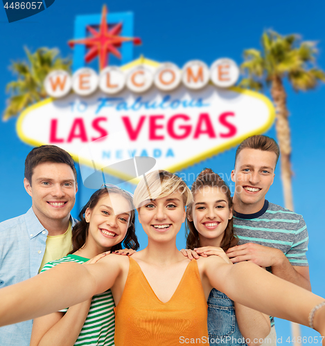 Image of happy friends taking selfie over las vegas sign