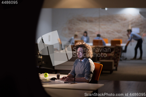 Image of man working on computer in dark office