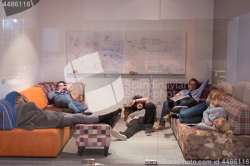 Image of software developers sleeping on sofa in creative startup office