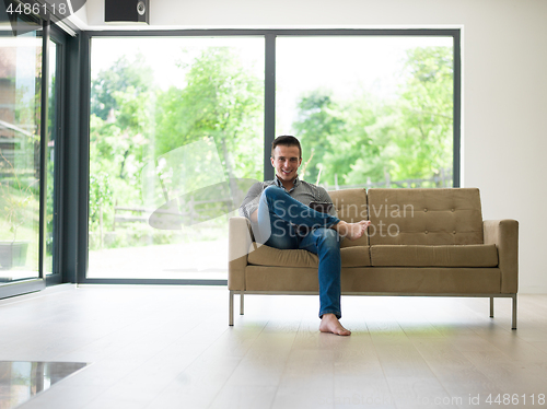 Image of man on sofa using tablet computer