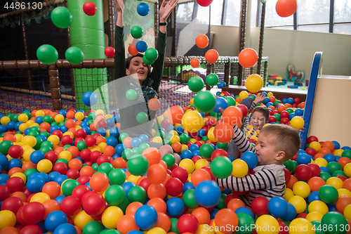 Image of Young mom with her kids in a children\'s playroom