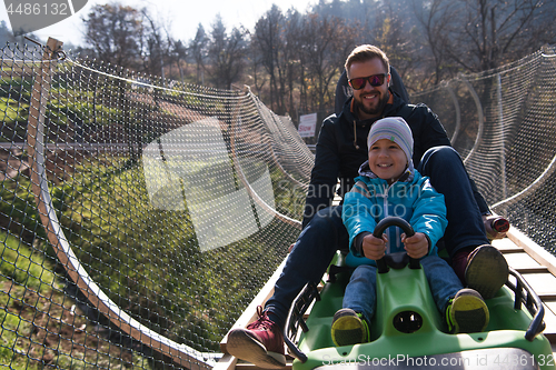 Image of father and son enjoys driving on alpine coaster