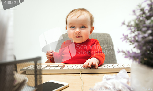 Image of Happy child baby girl toddler sitting with keyboard of computer isolated on a white background